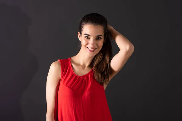 Uśmiechnięta młoda kobieta stojąca w studio — Zdjęcie stockowe