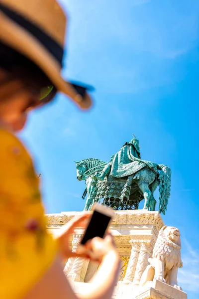 A young woman taking pictures of a landmark in the castle of Bud — Stock Photo, Image
