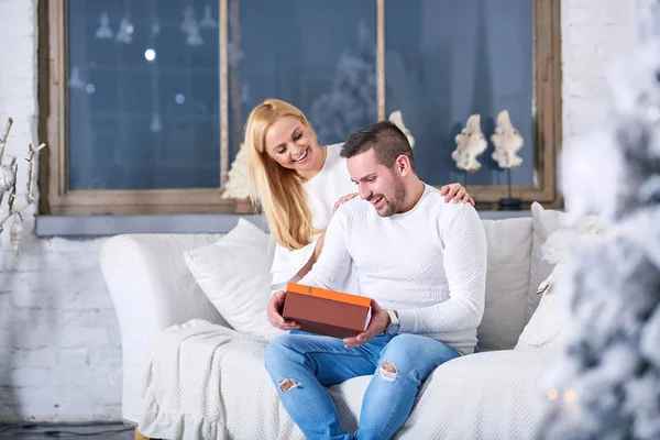 Casal em um sofá dando presentes — Fotografia de Stock