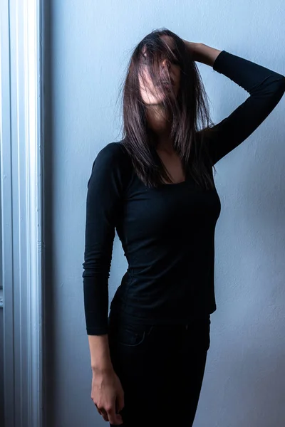 Retrato de humor escuro de uma mulher na frente de uma parede — Fotografia de Stock