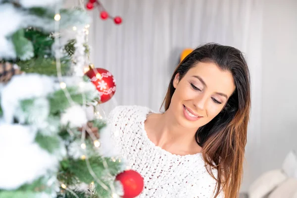 Красивая женщина украшает рождественскую елку — стоковое фото