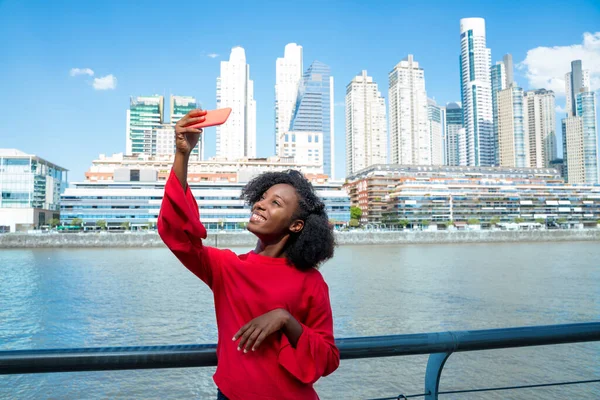 Uma jovem mulher tirando uma selfie na cidade — Fotografia de Stock