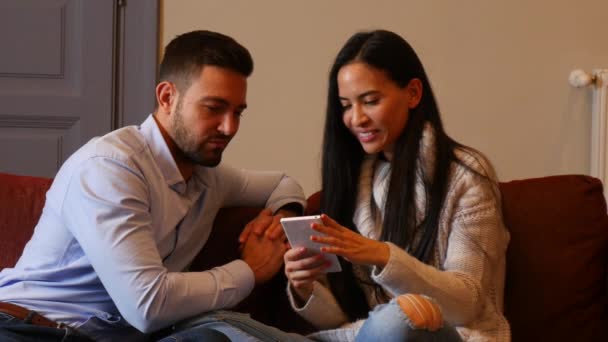 Beau Jeune Couple Dans Salon Discutant Contenu Sur Smartphone — Video