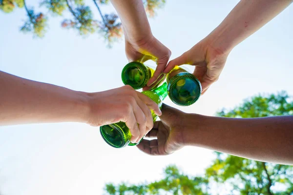 Sekelompok teman bersulang dengan bir di taman — Stok Foto
