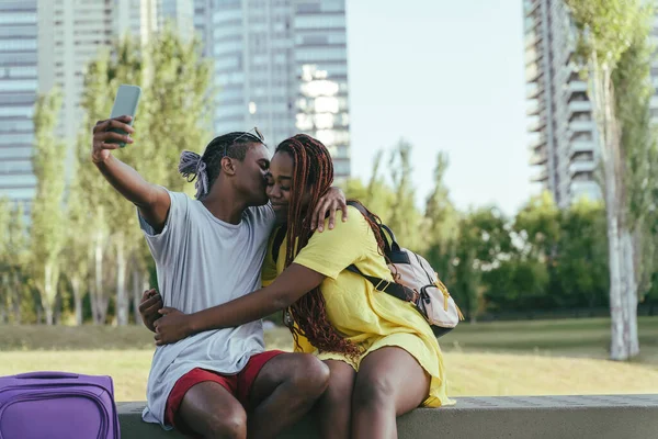 Um casal negro viajante tirando selfies em um parque — Fotografia de Stock