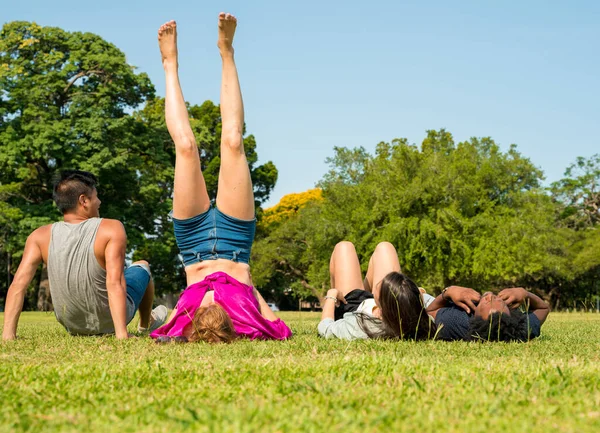 En grupp vänner som ligger tillsammans i gräsmattan — Stockfoto