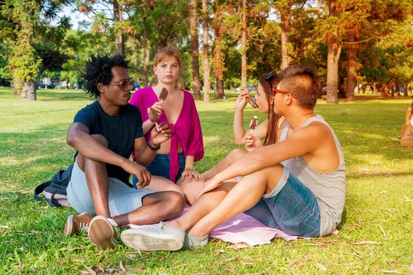 Sekelompok teman makan es krim bersama di taman — Stok Foto