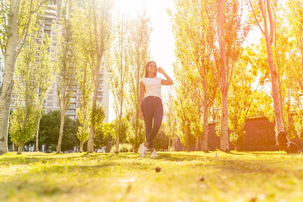 Молодая женщина позирует в парке в солнечный день — стоковое фото