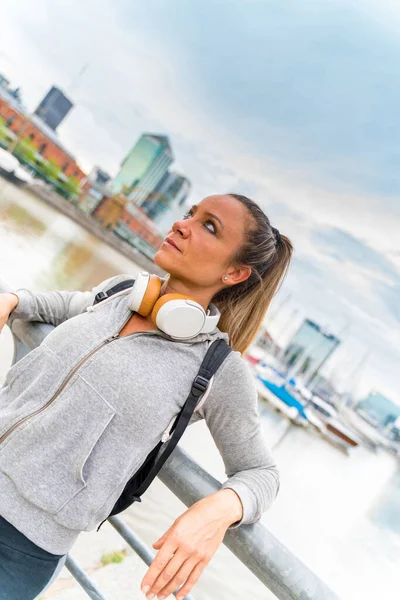 En atletisk kvinna vilar och lutar sig mot bron räcke — Stockfoto