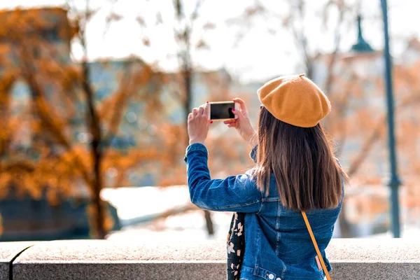 Una mujer tomando fotos en un parque de la ciudad — Foto de Stock