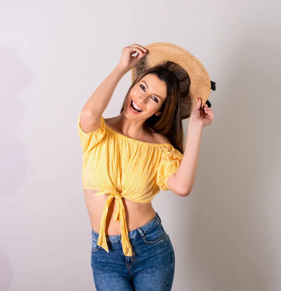 A happy woman in a yellow dress standing in a studio — Stock Photo, Image