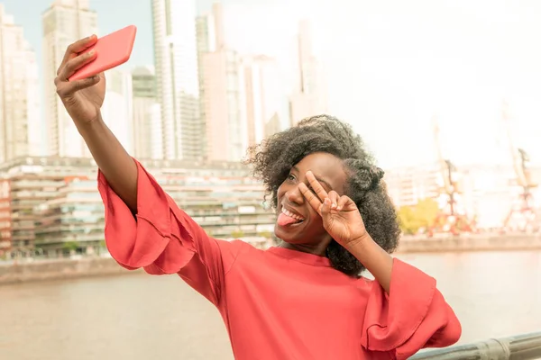 Uma jovem mulher tirando uma selfie na cidade — Fotografia de Stock