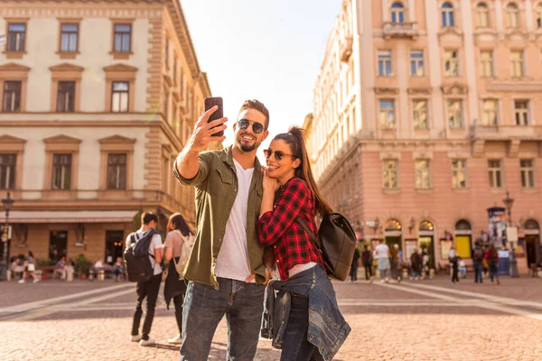 Um casal feliz tirando uma selfie na frente de um marco histórico — Fotografia de Stock