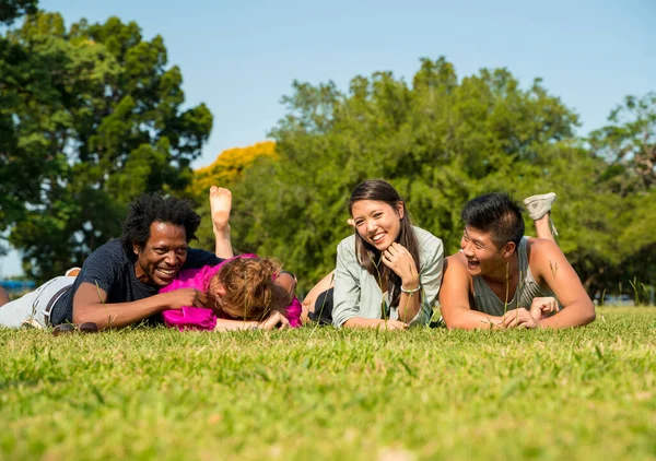 Un grupo de amigos tendidos juntos en el césped — Foto de Stock