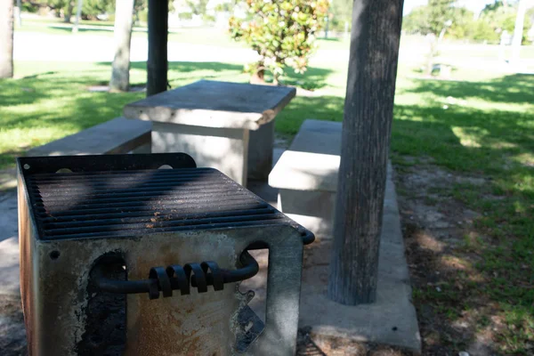 Old barbque grill next to picknick table — Stock Photo, Image