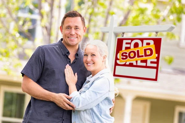 不動産の売却の記号と家の前で白人のカップル ストック画像