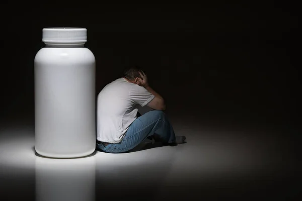 Man Holding Head Sitting Next Blank Medication Bottle — Stock Photo, Image