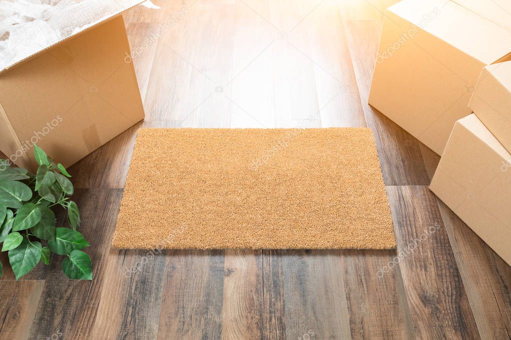 Blank Welcome Mat, Moving Boxes and Plant on Hard Wood Floors.
