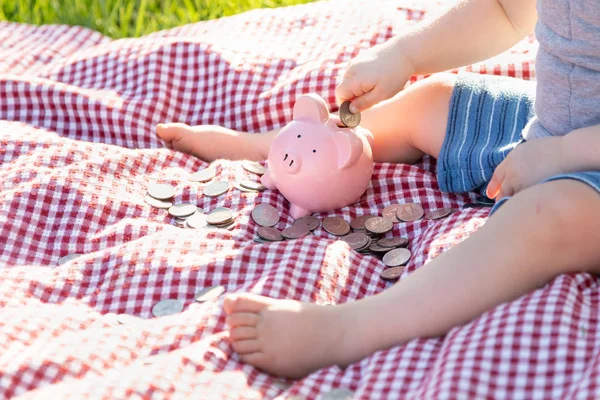 Menino Sentado Piquenique Cobertor Putting Moedas Piggy Bank — Fotografia de Stock