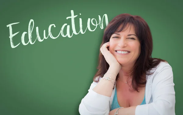 老化させた女性に教育中の笑顔の背後にある緑の黒板に書かれて — ストック写真