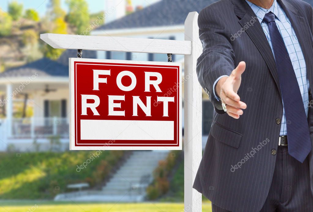 Male Agent Reaching for Hand Shake in Front of For Rent Sign and House.