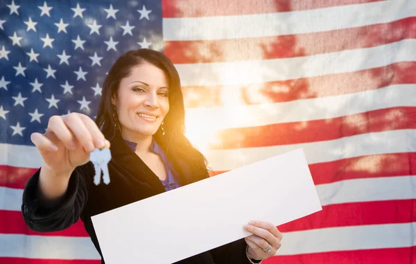 ヒスパニックの女性の家の鍵とアメリカの国旗の前に空白記号 — ストック写真