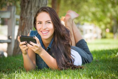 çim döşeme dışında cep telefonu üzerinde çekici mutlu karışık ırk genç kadın manifatura.