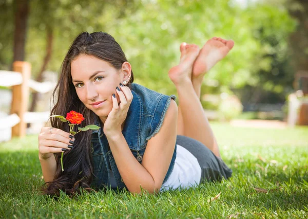 屋外の花草に敷設魅力的な混血の少女の肖像画 — ストック写真