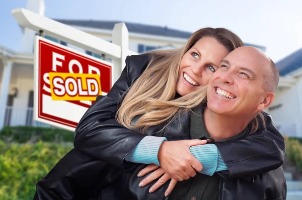 不動産の売却の記号と家の前で抱き締めて幸せなカップル ストック画像