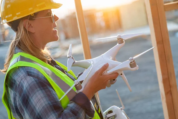 Female Unmanned Aircraft System (UAS) Quadcopter Drone Pilot Holding Drone at Construction Site.