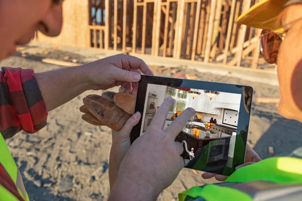 Erkek ve dişi inşaatı işçiler mutfak bilgisayar defterinde inşaatı sitesinde gözden geçirme.