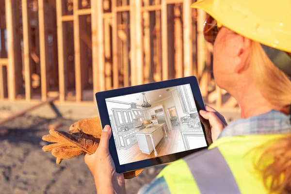 Female Construciton Worker Reviewing Kitchen Illustration on Computer Pad at Construciton Site.