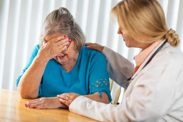 Female Doctor Consoling Distraught Senior Adult Woman — Stock Photo, Image