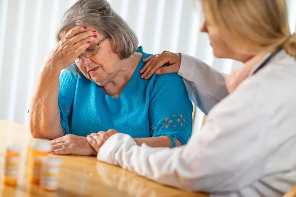 Female Doctor Consoling Distraught Senior Adult Woman — Stock Photo, Image