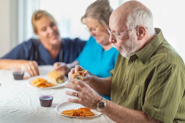 Женщина Врач Медсестра Обслуживающая Сендвичи Пожилых Людей Столом — стоковое фото