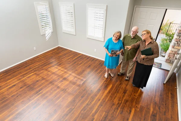 Female Real Estate Agent Showing Senior Adult Couple New Home — Stock Photo, Image