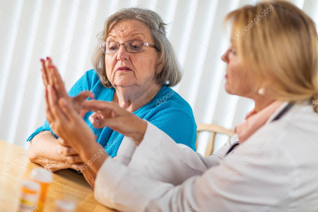 Female Doctor Talking with Senior Adult Woman About Hand Therapy.