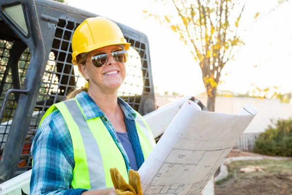 Sorrindo Feminino Trabalhadora Segurando Plantas Técnicas Perto Pequeno Bulldozer Sítio — Fotografia de Stock