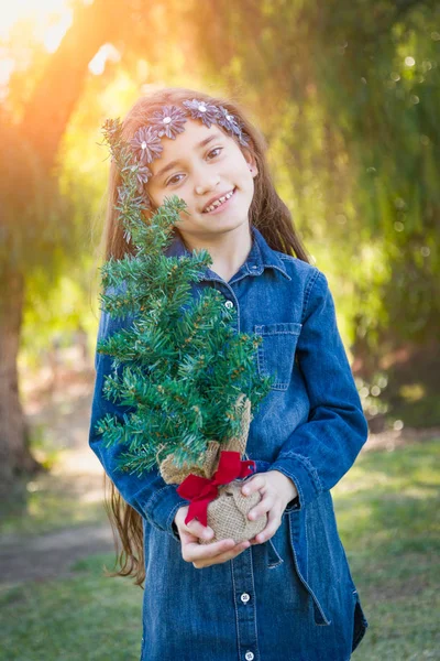 Cute Mixed Race Young Girl Holding Small Christmas Tree Outdoors — Stock Photo, Image