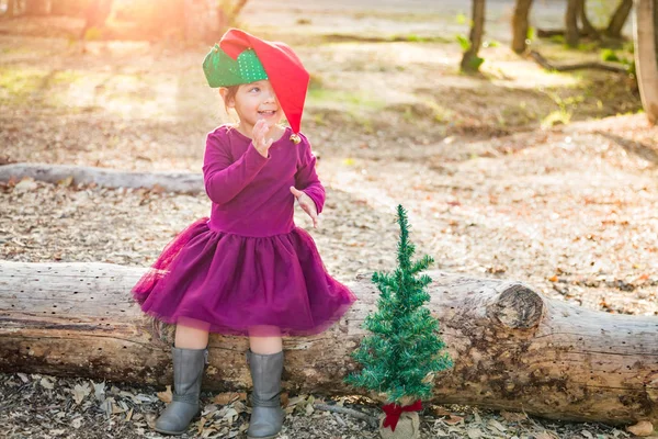 かわいい混血若い赤ちゃん女の子屋外クリスマス帽子とツリーで楽しんで — ストック写真
