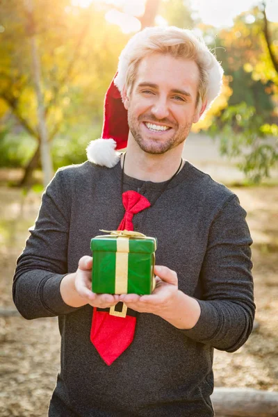 Handsome Festive Young Caucasian Man Holding Christmas Gift Outdoors — Stock Photo, Image
