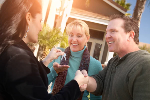 Hispanic Vrouwelijke Makelaar Nieuwe Huis Sleutels Overhandigen Aan Gelukkige Paar — Stockfoto