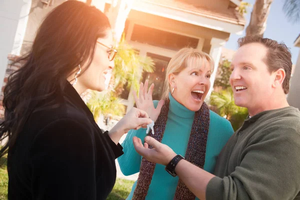 Hispanic Female Real Estate Agent Handing New House Keys Happy Stock Photo