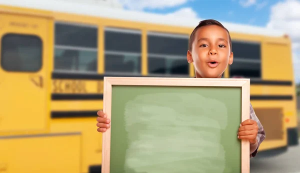 年轻的西班牙裔男孩与空白黑板接近校车 — 图库照片