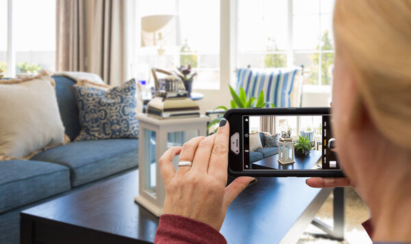 Woman Taking Pictures of A Living Room in Model Home with Her Smart Phone.
