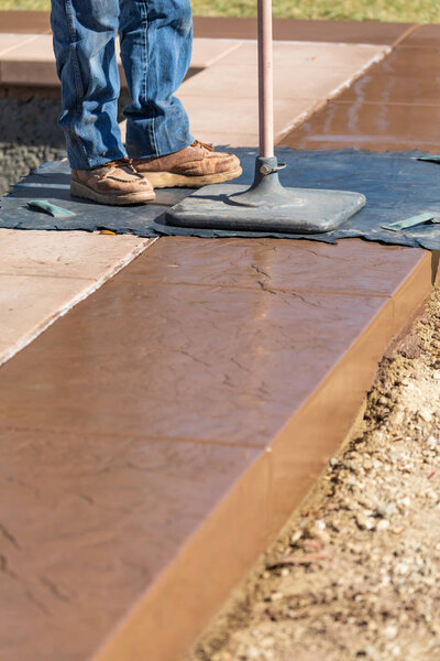 Construction Worker Applying Pressure to Texture Template On Wet Cement