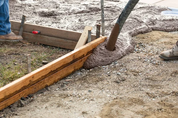 Bauarbeiter schüttet nassen Deckbeton in Holzrahmen — Stockfoto