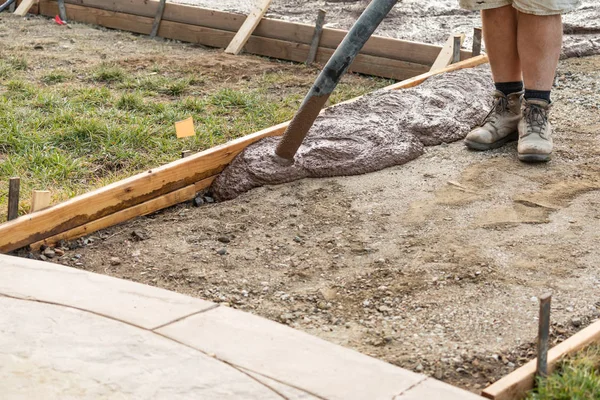 Trabajador de la construcción pobreciendo cemento húmedo de la cubierta en el marco de madera — Foto de Stock