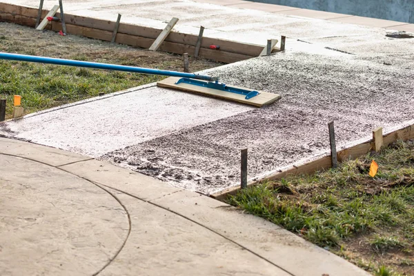 Bauarbeiter glättet nassen Zement mit Spachtel — Stockfoto