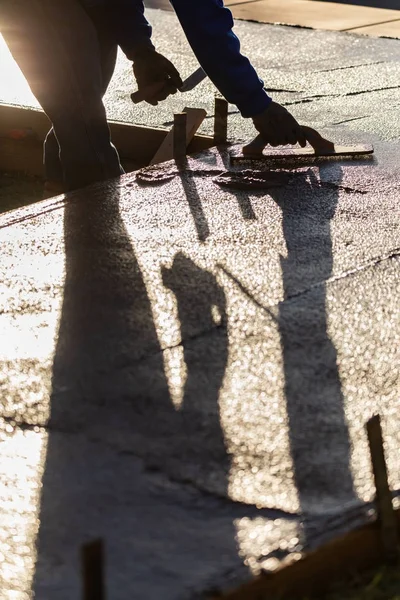 Bauarbeiter glättet nassen Zement mit Spachtelwerkzeug — Stockfoto